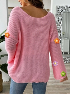 Detail des rosa Strickpullovers mit bunten 3D-Häkelblumen-Applikationen auf dem Ärmel