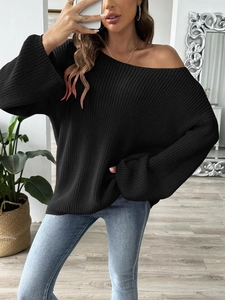 Macro shot of a black off-shoulder knitted sweater with flare sleeves and thick texture