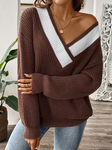 Détail d'un pull en maille côtelée marron foncé avec col en V et rayures blanches