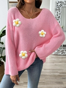 Detail of pink knit off-shoulder sweater showing delicate handmade 3D floral appliqués
