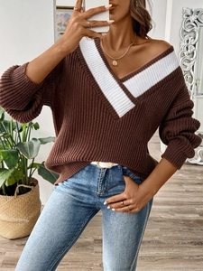 Détail du pull en maille oversize avec col en V contrasté blanc et texture côtelée
