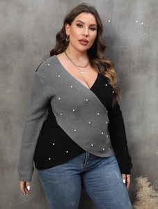 Detail of plus size wrap sweater featuring V-neck, colorblock knit, and pearl bead accents