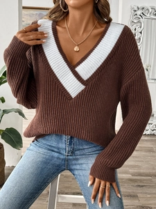 Détail du col en V avec empiècements blancs contrastés sur pull en maille marron