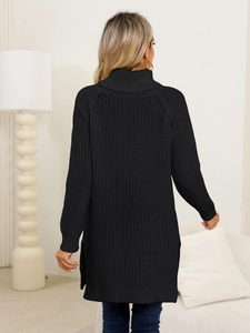 Detail of black turtleneck knit dress with vertical ribbed texture and side split hem