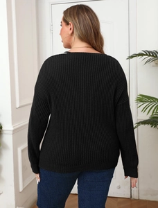 Detail of black ribbed knit sweater featuring pearl beaded accents and V-neckline texture