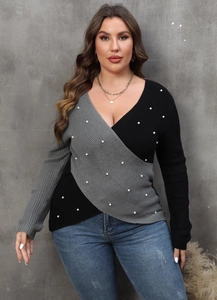 Detail of color-block knit sweater with deep V-neck and decorative white pearls