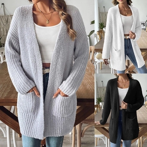 Close-up of thick knitted cardigans with pockets in gray, white, and black colors