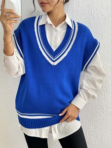 Detail of royal blue V-neck knit vest with white stripe texture and collegiate design