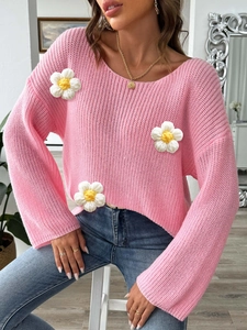Close-up of pink hollow knit sweater featuring 3D handmade crochet daisy floral patches
