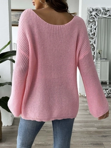 Detail of pink knit sweater featuring a wide V-back cut and delicate openwork texture