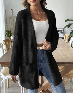 Detailed close-up of a black textured popcorn knit cardigan with functional side pockets