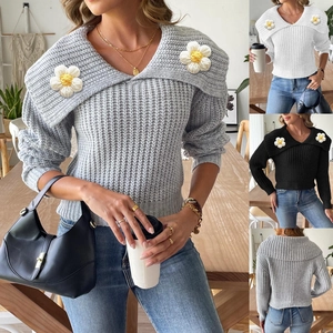 Detail of chunky knit sweater with three-dimensional crochet flower on large collar
