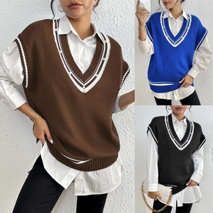 Dettaglio del gilet in maglia con scollo a V, righe a contrasto e decori di perle