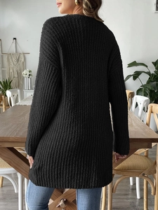 Detailed back view of a black knit cardigan showing loose fit and vertical stripe texture
