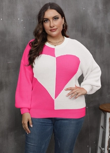 Detail view of the ribbed round neckline and heart pattern on pink knit sweater