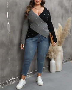 Detail view of plus size knit sweater with deep V-neck, color block panels and pearl beads