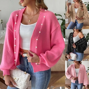 Detail of knit cardigan featuring textured ribbing and elegant pearl bead embellishments