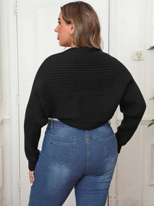 Dettaglio del cardigan nero in maglia a coste che mostra la trama e il taglio corto
