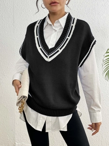 Dettaglio di un gilet in maglia stile collegiale con scollo a V e decorazioni di perle