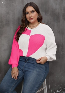Detail shot of plus size sweater featuring bright pink heart patchwork and thick knit texture