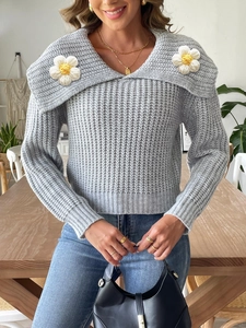 Close-up of grey knit sweater featuring large collar and white 3D floral crochet details