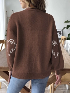 Detail of white ghost jacquard on brown oversized knitted Halloween cardigan