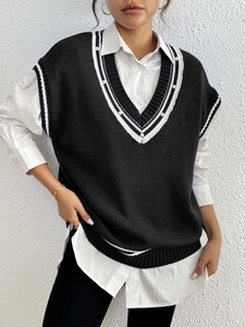 Dettaglio del gilet in maglia con scollo a V, strisce a contrasto e decorazioni di perle