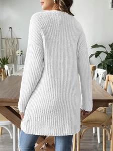 Detail of white chunky knit cardigan featuring oversized fit and ribbed texture surface