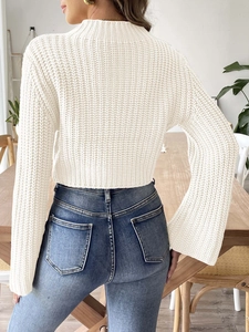 Detailed back view of a cream knit cropped sweater featuring flared sleeves and mock neck