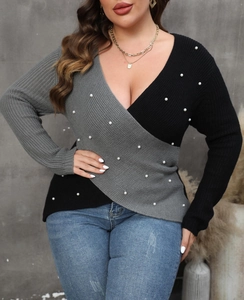 Detail of color-block knit sweater with deep V-neck and decorative white pearls