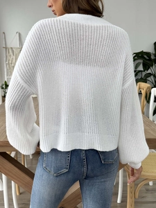 Vista posteriore di un cardigan in maglia traforata bianca con maniche a lanterna ampie