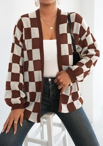Dettaglio del cardigan in maglia a scacchi con spalle calate e motivo marrone e bianco