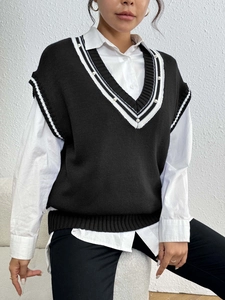 Dettaglio del gilet in maglia con scollo a V, strisce a contrasto ed eleganti perle applicate