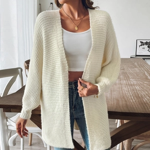 Gros plan d'un long gilet en tricot blanc crème avec texture côtelée et manches lanterne