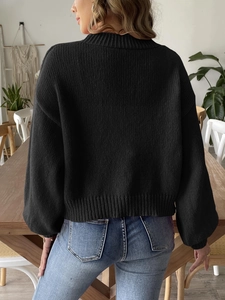 Detail of classic black long sleeve knit sweater with ribbed cuffs and loose casual fit