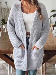 Close-up of soft plush knit texture and functional side pockets on a women's cozy cardigan