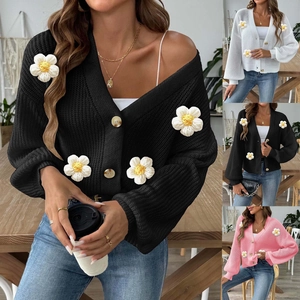 Detail of hand-crocheted 3D daisy flowers on a soft V-neck knit cardigan sweater