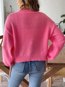 Detailed back view of a pink knitted drop-shoulder cardigan with ribbed hem and cuffs