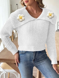 Close-up of 3D crochet daisy detail on white knit sweater with large collar