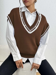 Dettaglio del gilet in maglia con scollo a V, strisce a contrasto e perle applicate
