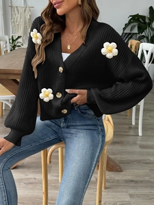 Women's black V-neck knit cardigan with white 3D floral accents and amber buttons