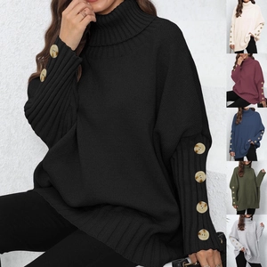 Close-up of ribbed knit sweater sleeve with decorative marble pattern buttons and high collar