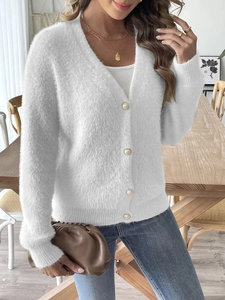 Dettaglio del cardigan bianco in finta pelliccia con bottoni decorativi in perla