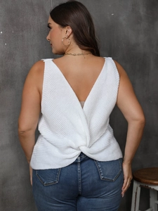 Détail du dos d'un débardeur blanc en maille avec col en V profond et nœud torsadé chic