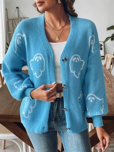 Detail of light blue Halloween cardigan with white ghost knit patterns and dark buttons