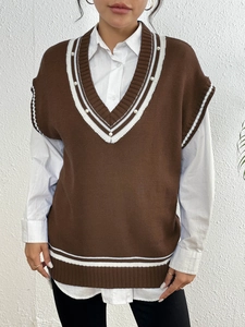 Dettaglio del gilet in maglia con scollo a V, strisce a contrasto e decorazioni di perle