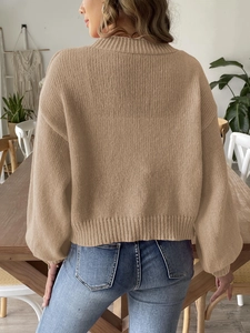 Detail of knitted cardigan with rib-knit cuffs and drop shoulder back view in home setting