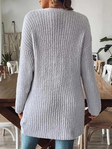 Rear view of a textured purple chenille knit cardigan for women in a cozy room setting