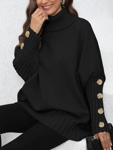Detailed close-up of oversized black knit sweater featuring turtleneck and decorative buttons