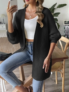 Détail du cardigan noir en tricot à côtes verticales et coupe décontractée aux épaules